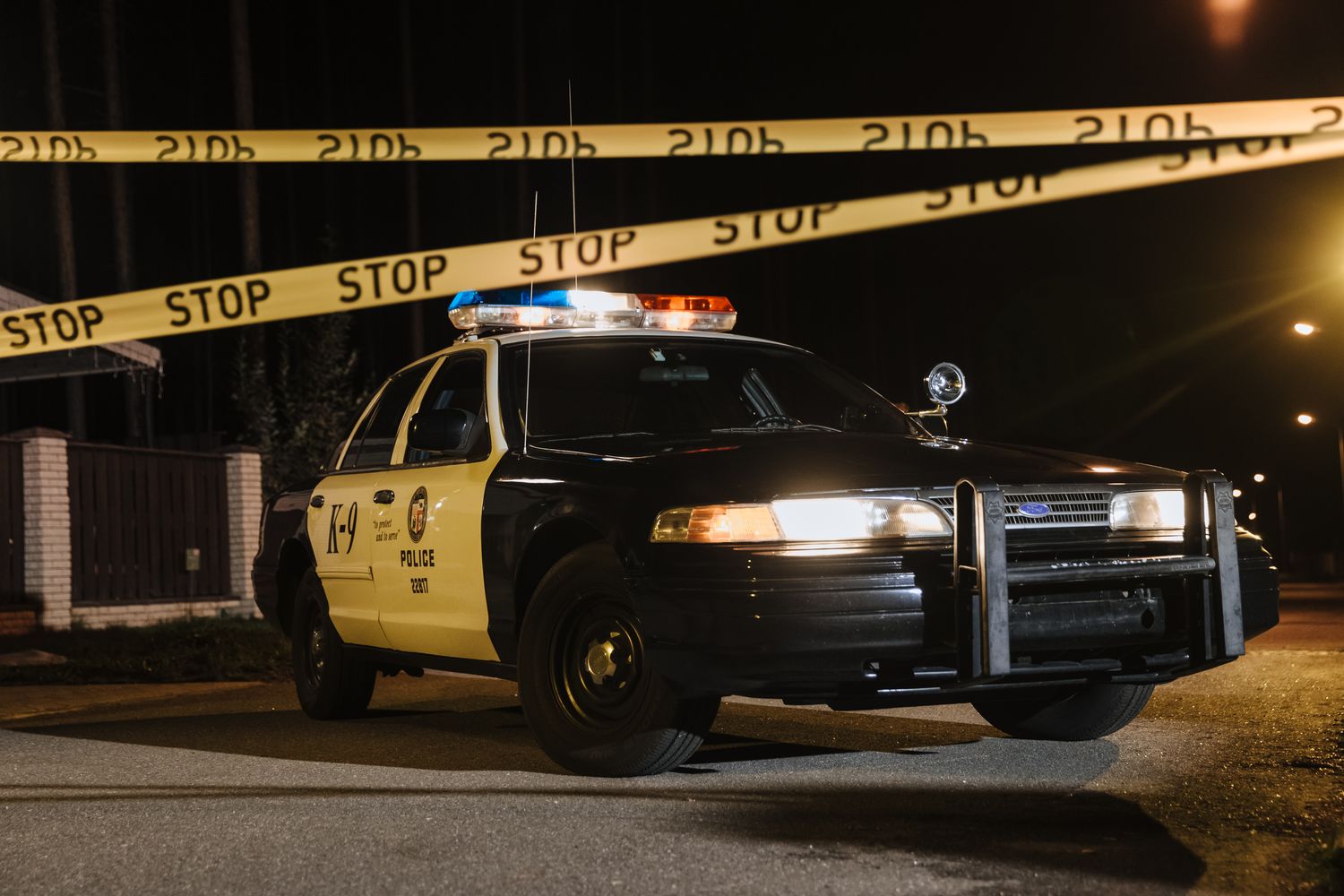 Police vehicle with lights near crime scene tape