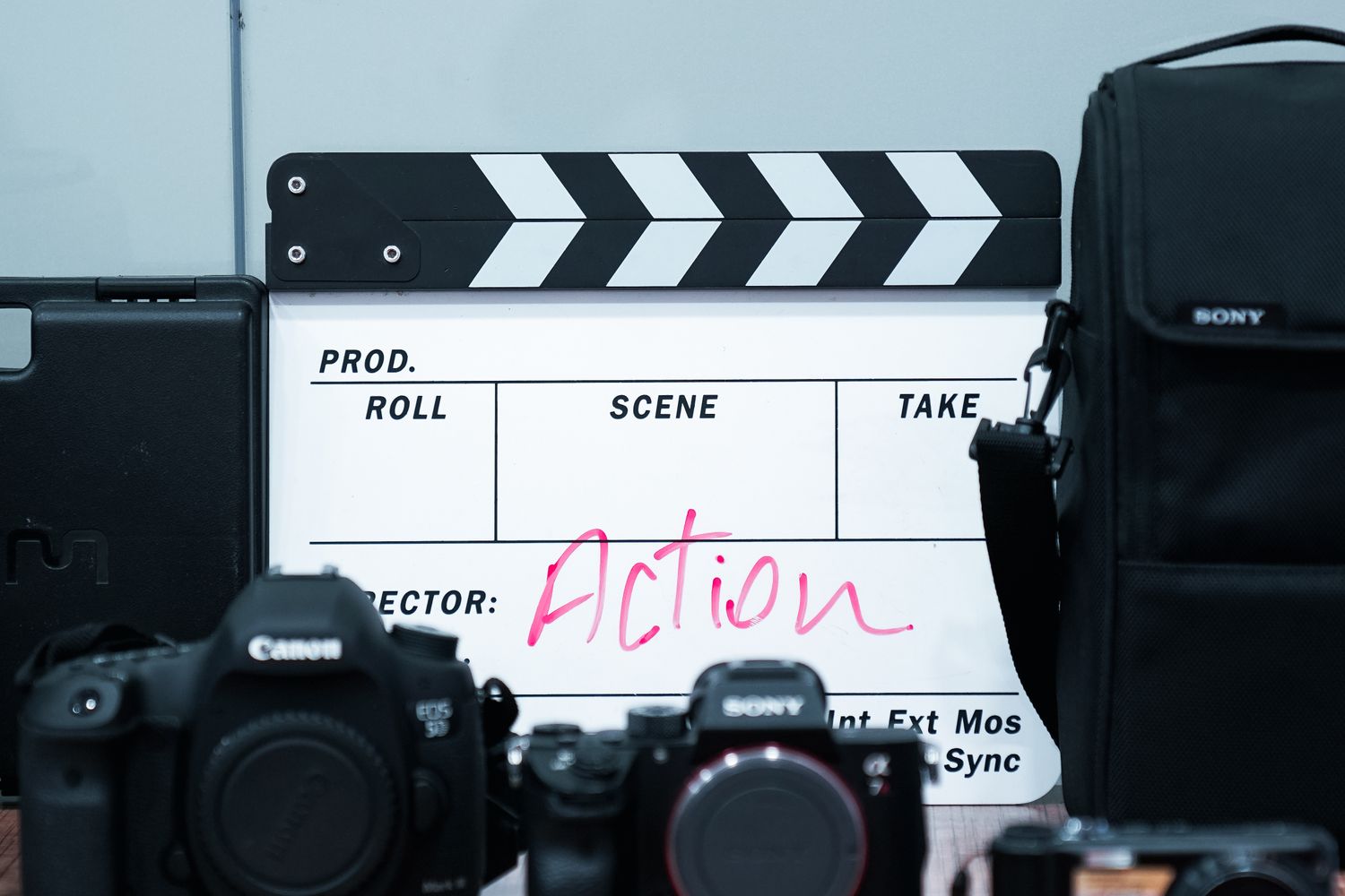 A film clapperboard and camera equipment on an active movie set