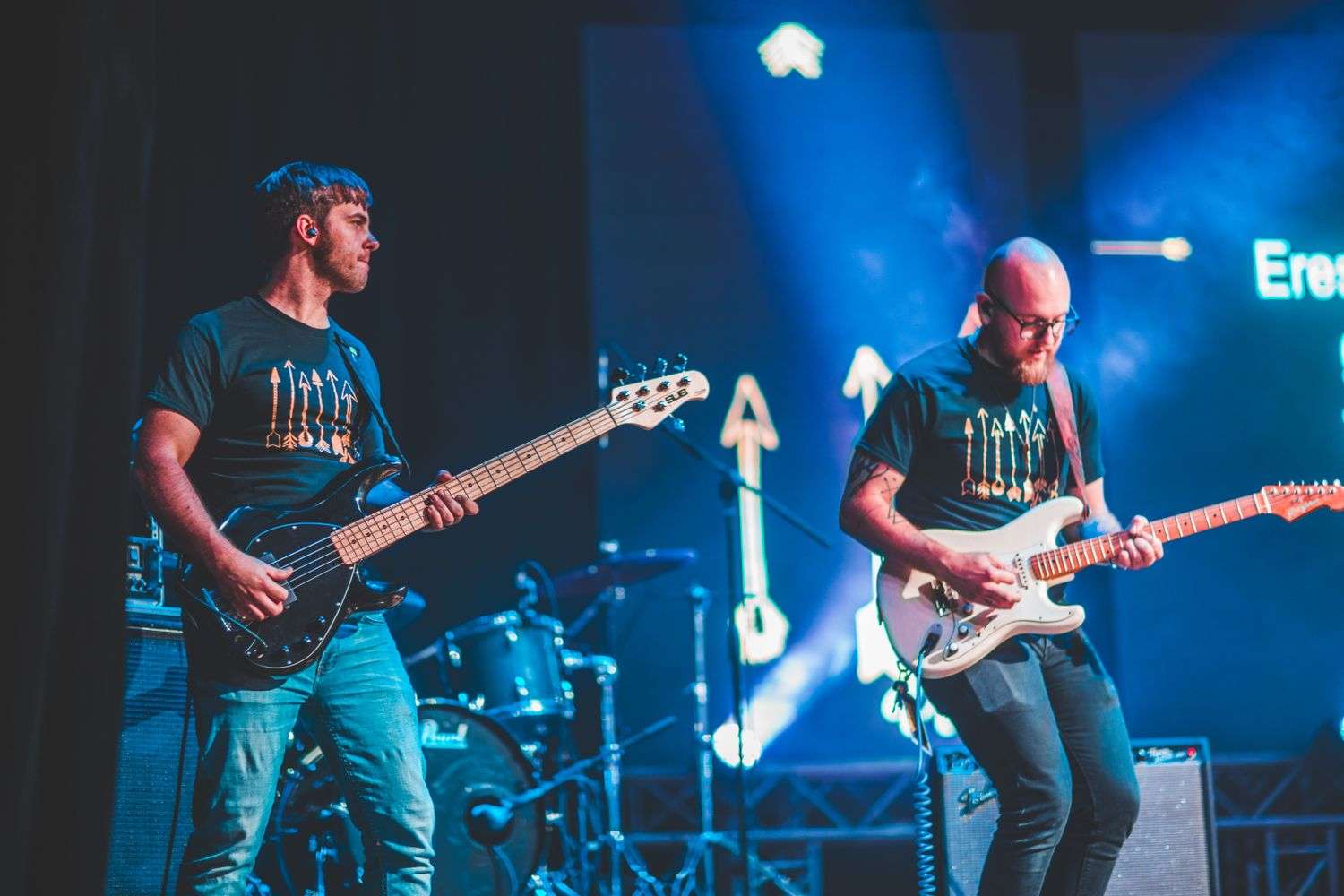 A local indie rock band performing on stage with electric guitars