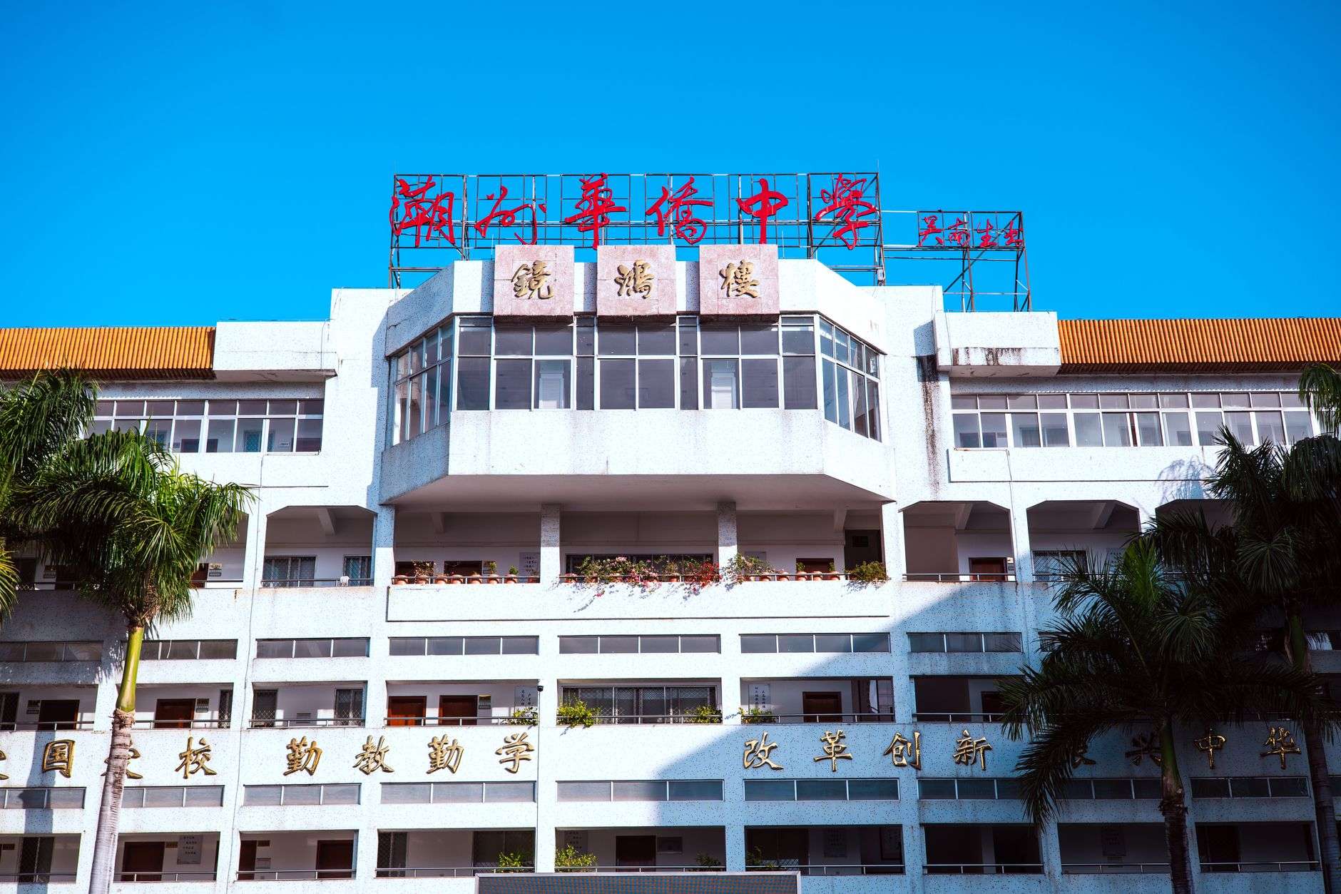The exterior of a modern high school campus with large windows and landscaped grounds.