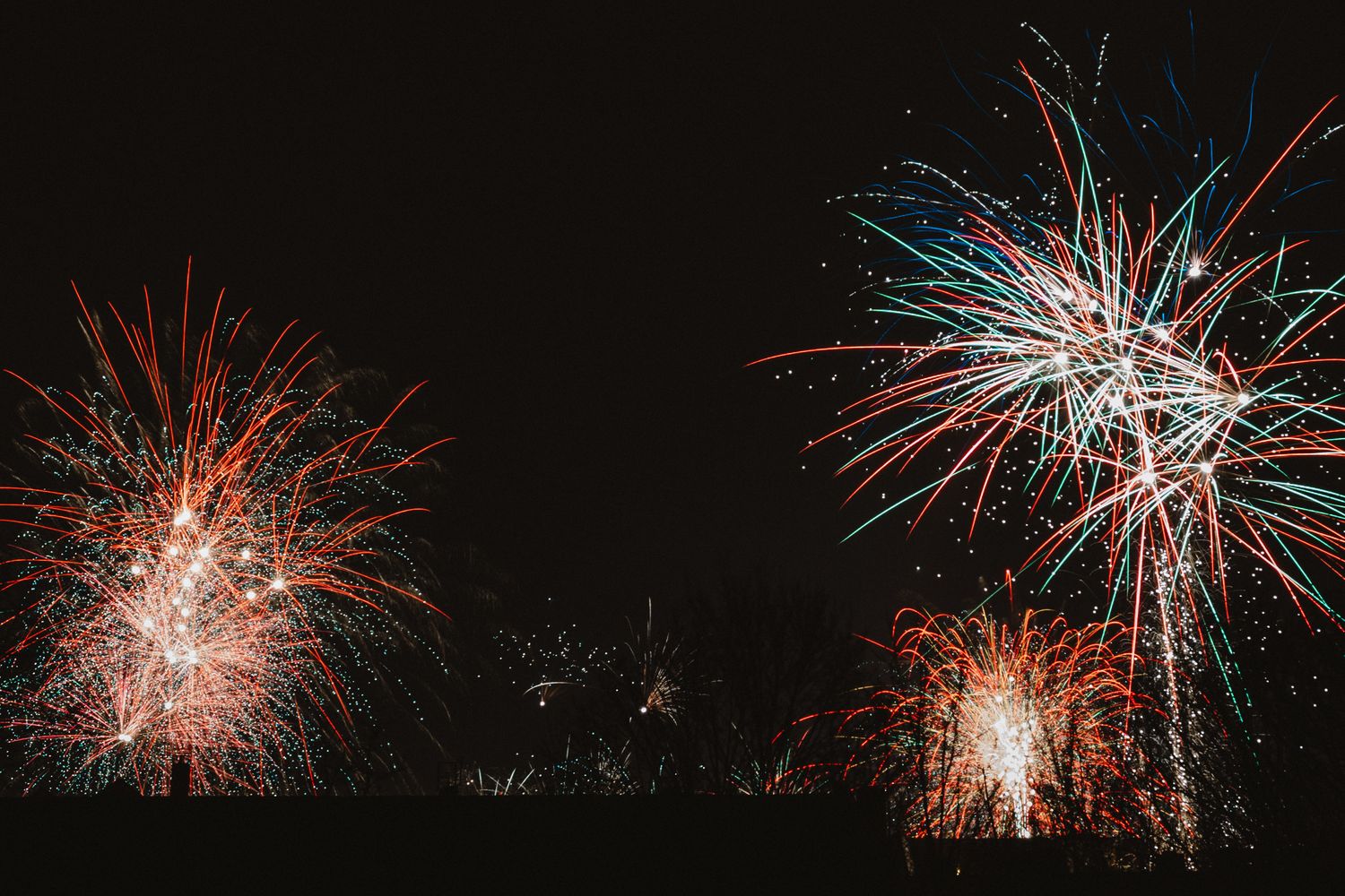 Fireworks burst above a city skyline on New Year's Eve
