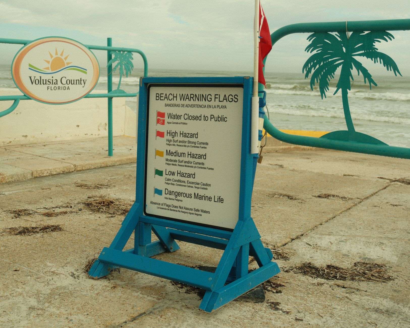 Rough ocean waves near a beach warning flag