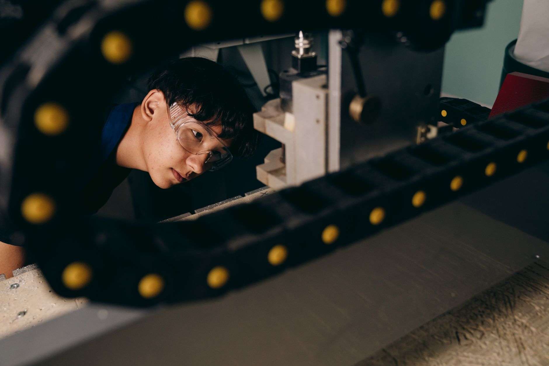 A student in safety gear touring an industrial manufacturing facility