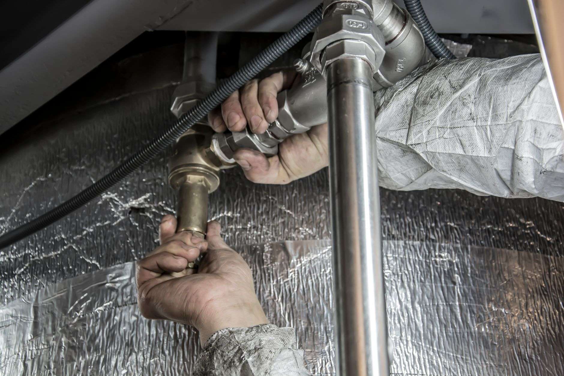 A plumber connecting fittings on an underground sewer pipe