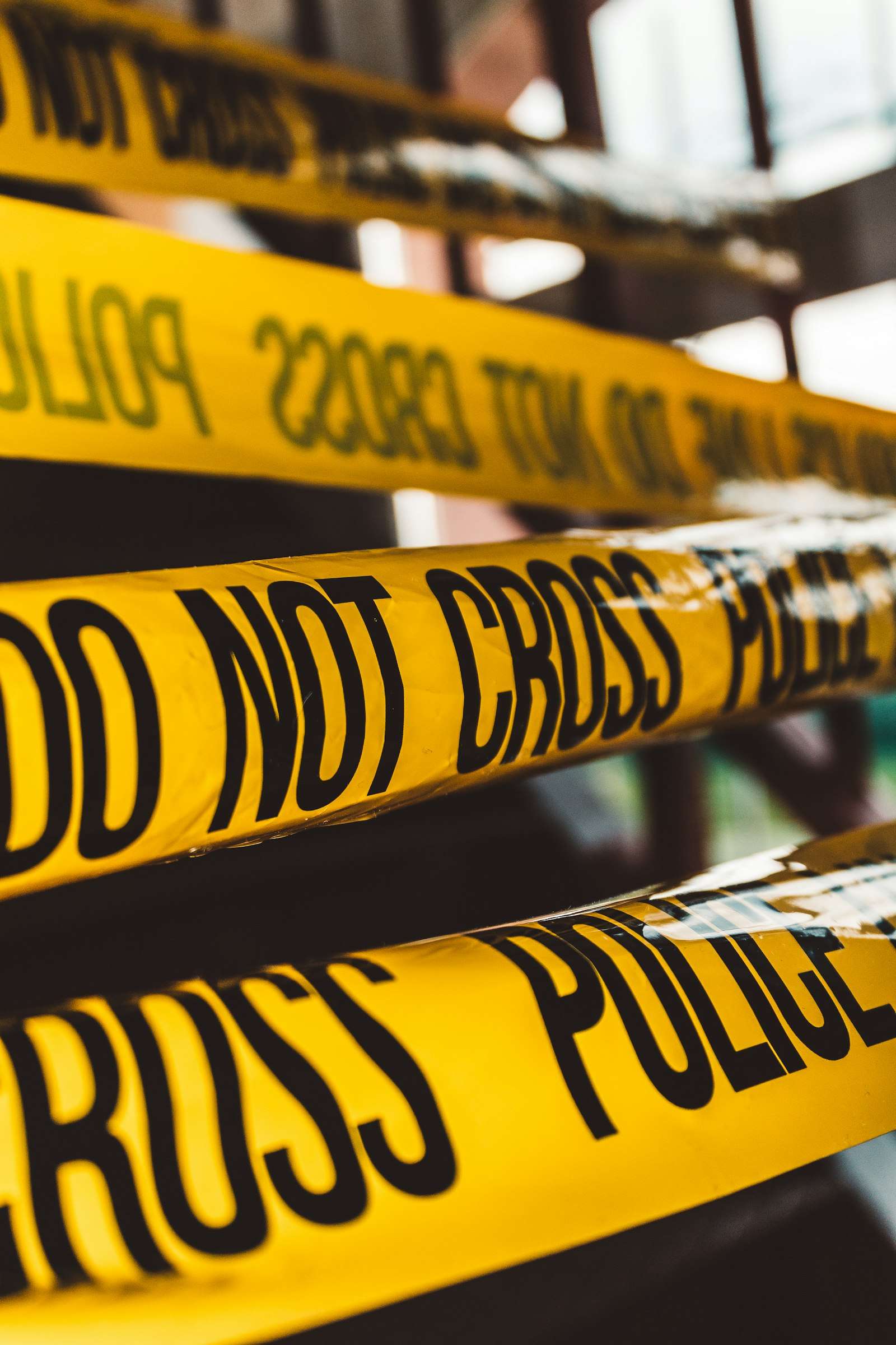 Yellow police line tape stretched across a street at a crime scene