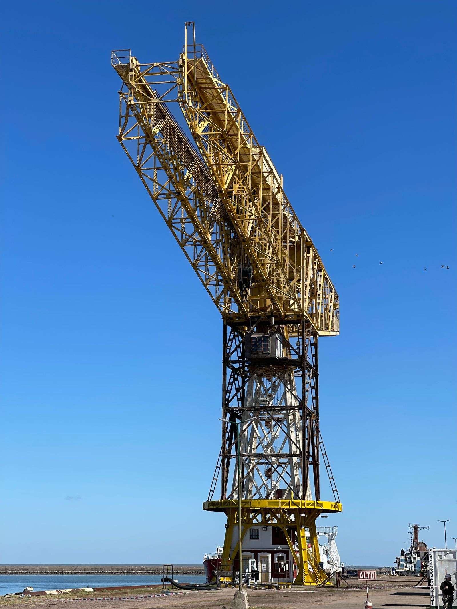 A large industrial crane at the Port of Mobile against a clear sky