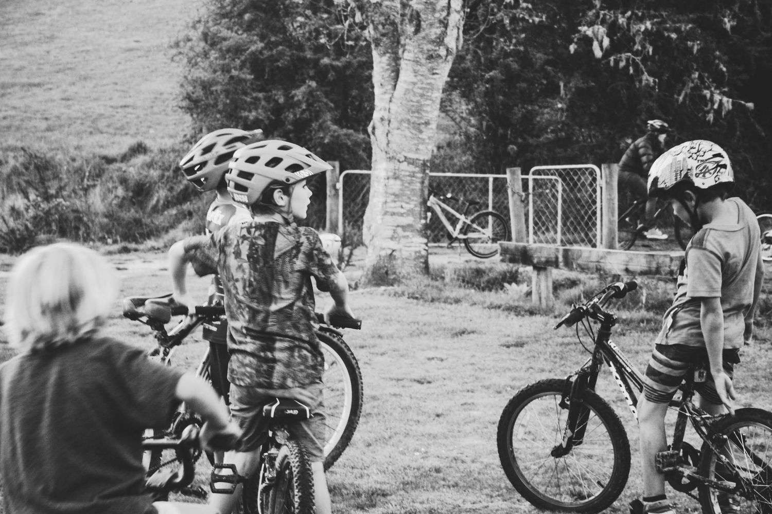 Children wearing bicycle helmets standing outdoors with their bikes