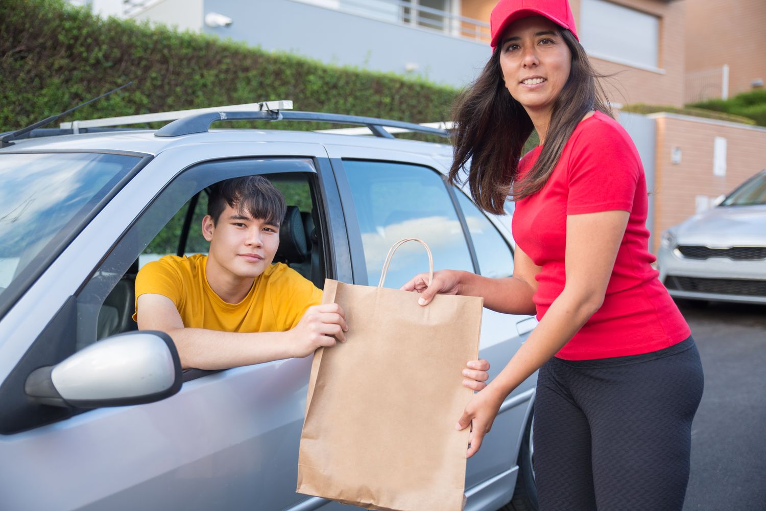 Volunteers loading boxes of food into cars at a drive-through community food pantry