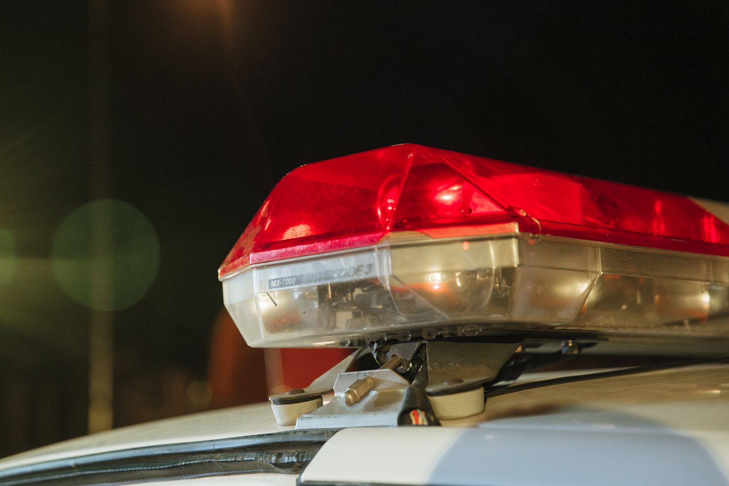 Police car with flashing blue and red lights on a dark street