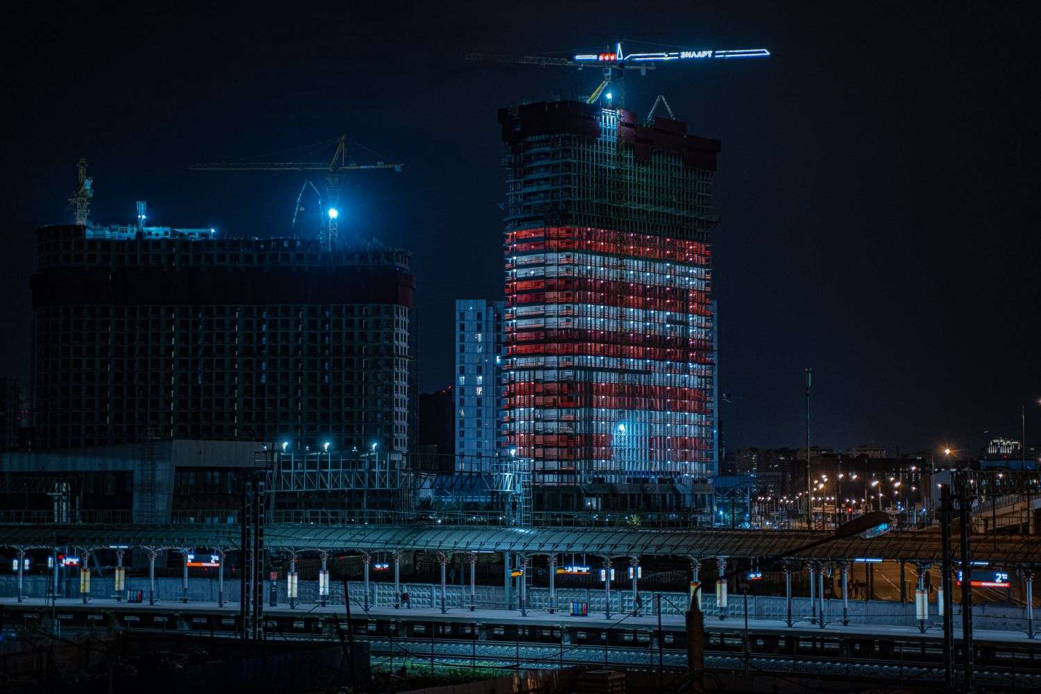 A building exterior lit with red lights against the night sky