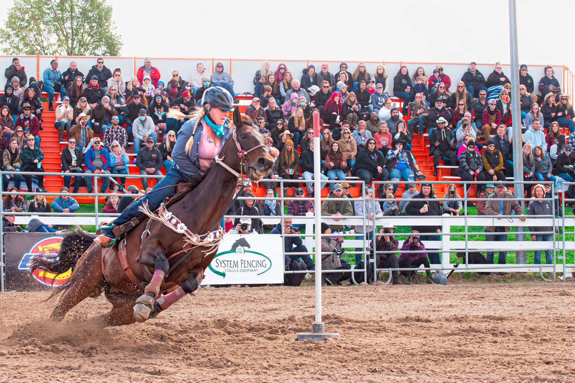 Rider competing in a barrel race at a rodeo arena