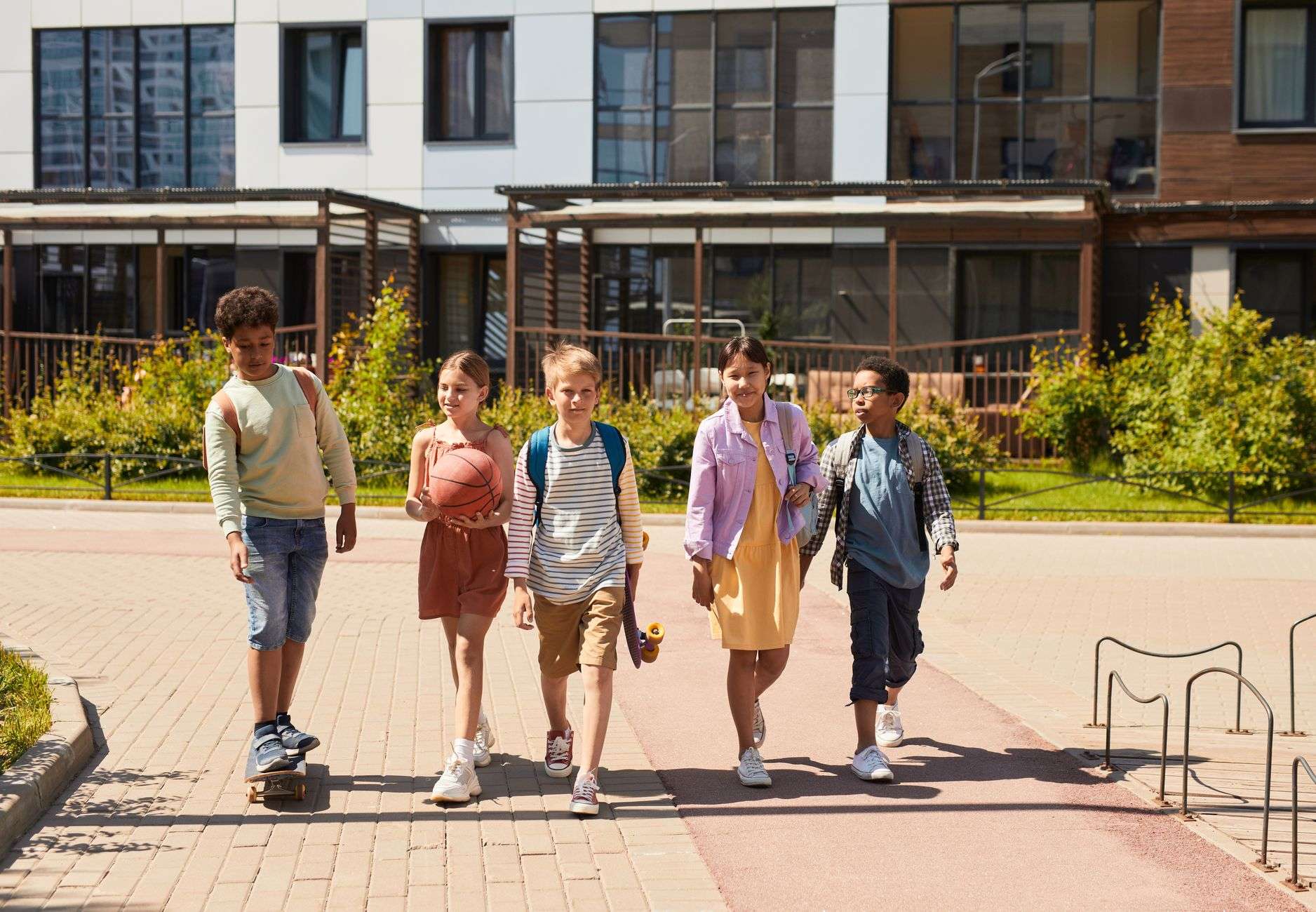 A group of students walking together along a neighborhood sidewalk after school