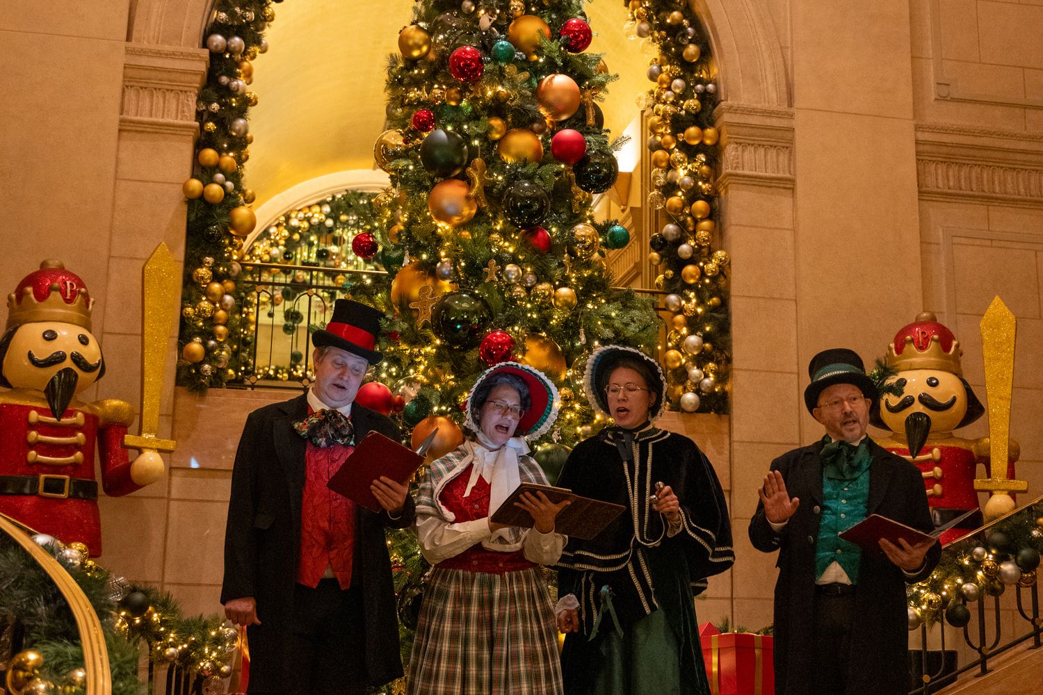 Performers in Victorian-era costume on a holiday theater stage