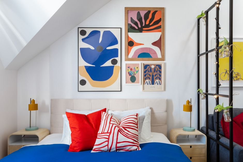 Colorful boys bedroom with patterned wallpaper, red wainscoting and vintage furniture
