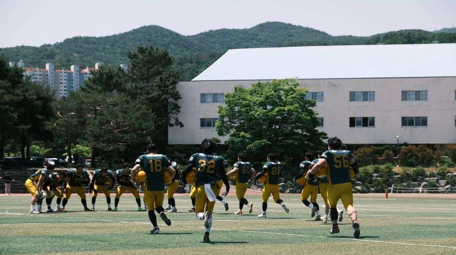 Football team practicing outdoors during fall camp