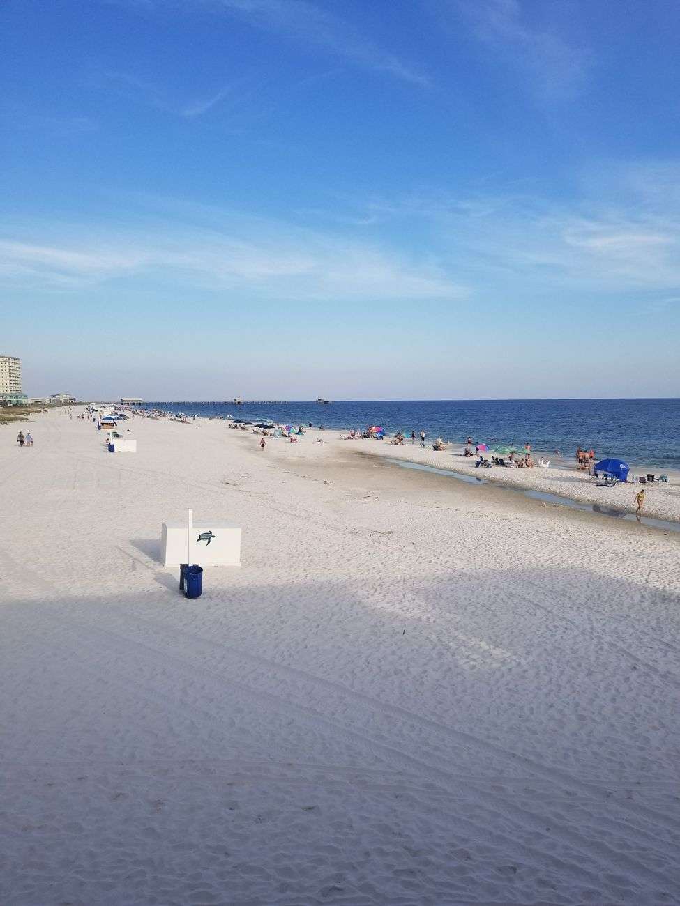 A sunny beach with white sand, blue water and clear sky along the Gulf Coast