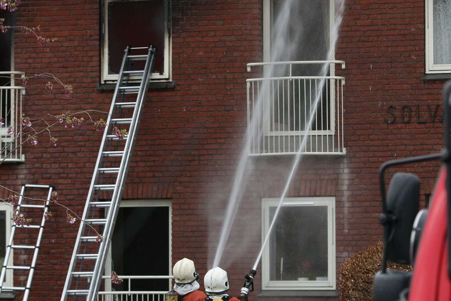 Firefighters spraying water on a burning house