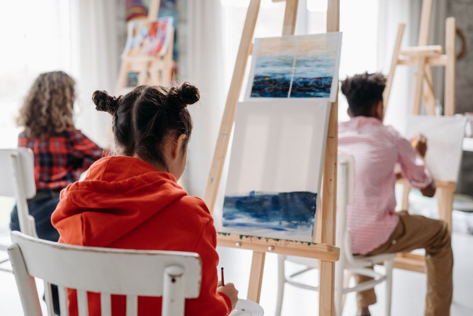 Young artist working on a painting during art class