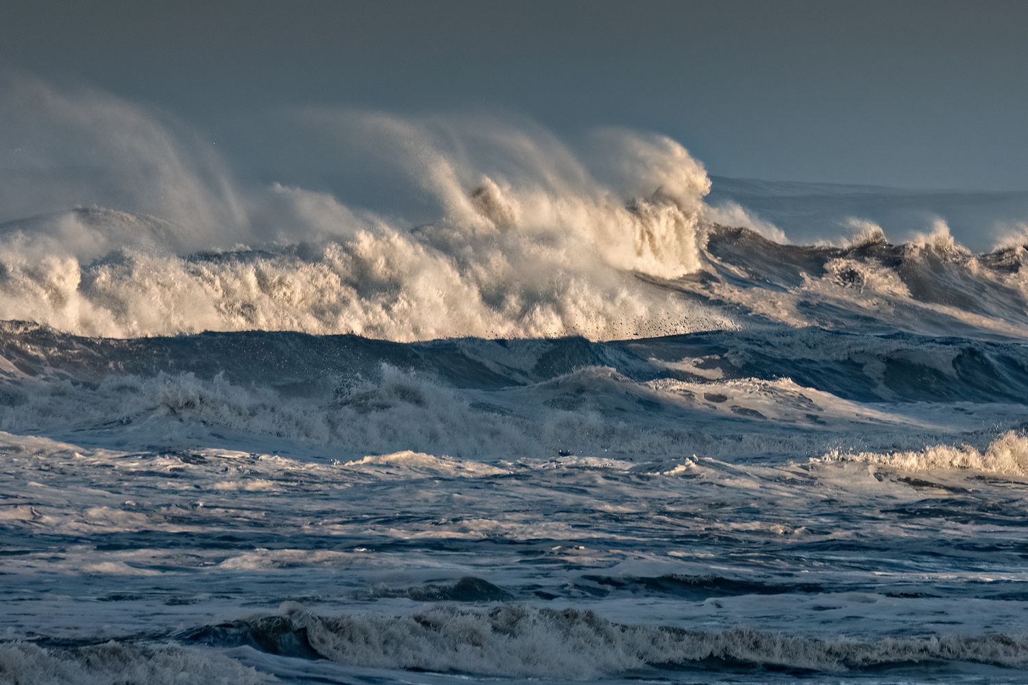 Large waves crashing in stormy ocean waters