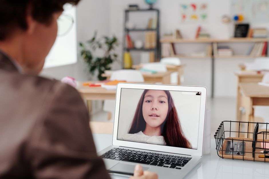 A student attending class online with a laptop