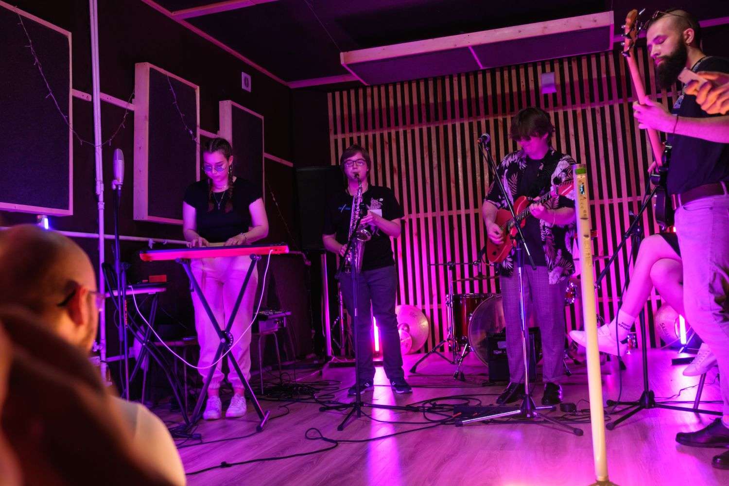 A band performing on a small stage at a downtown Mobile bar