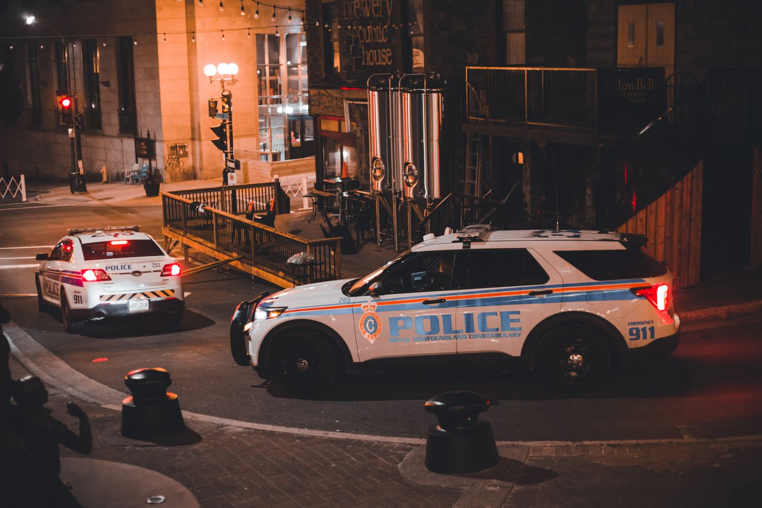 A police car with emergency lights activated outside a small retail store