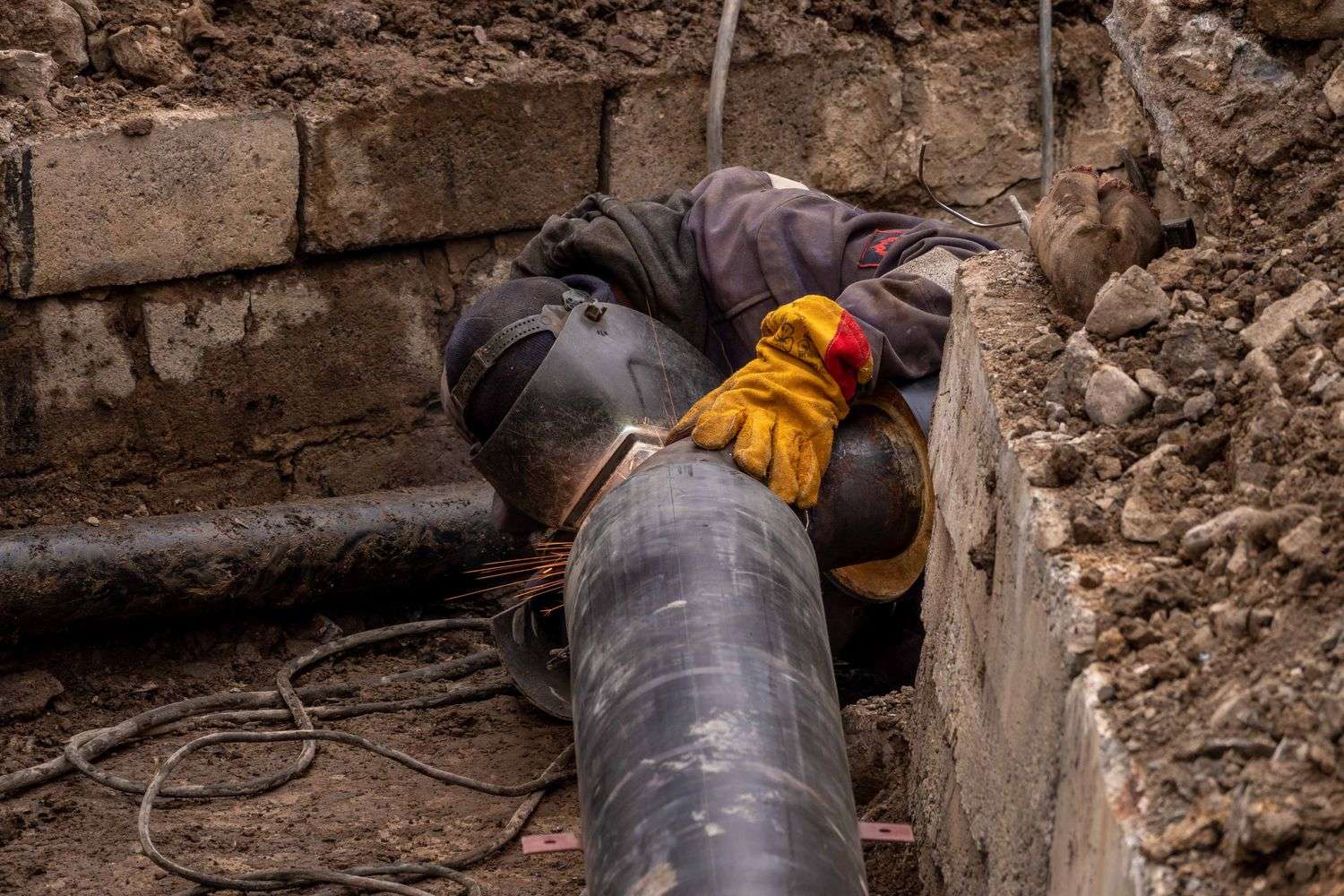 Utility worker repairing a water pipe in a street