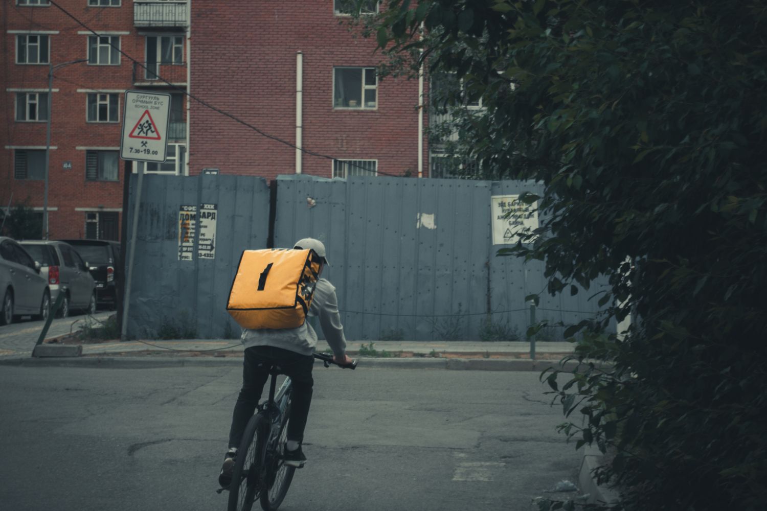 A bicycle messenger rides through a downtown street on a delivery