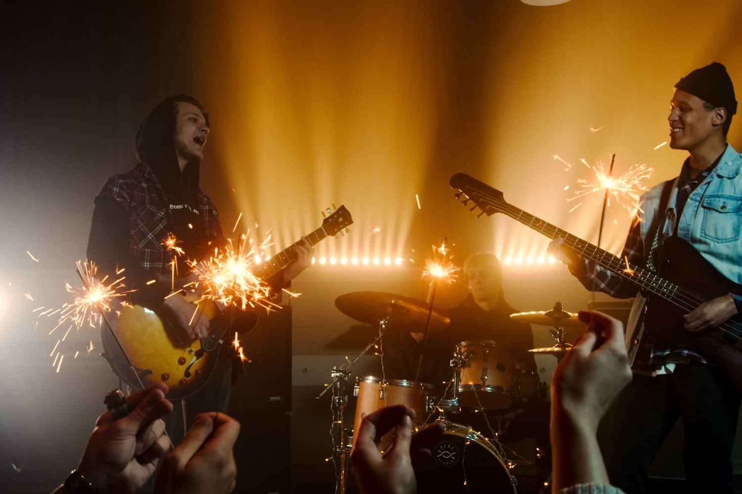 An indie rock band performing live under stage lights at a small music club