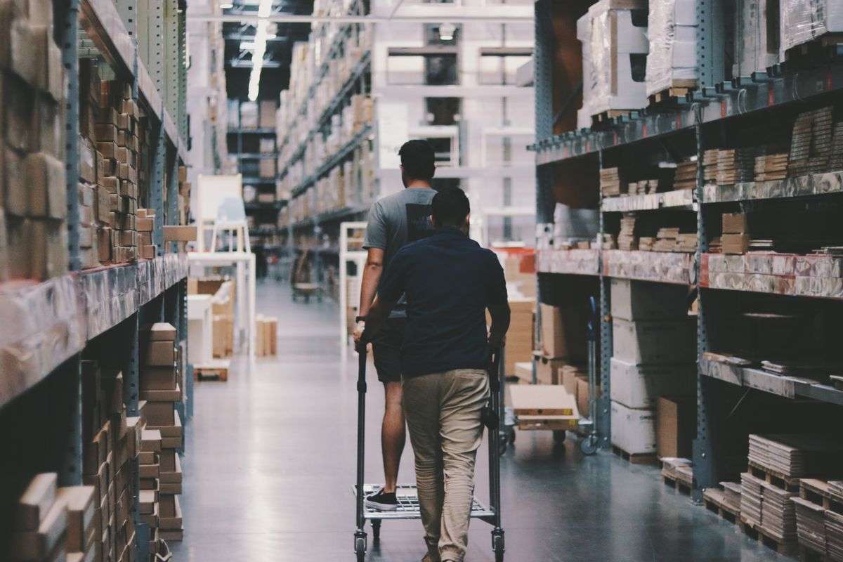 Workers moving stock on shelves inside a farm and ranch supply warehouse