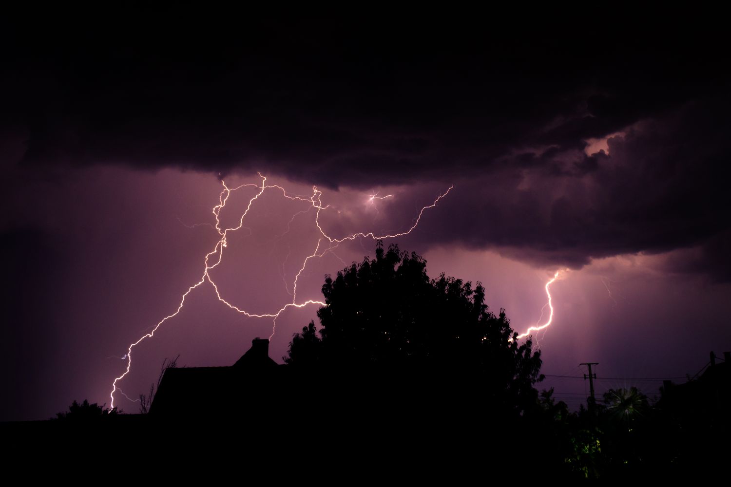 A lightning bolt during a severe thunderstorm over a rural Alabama treeline
