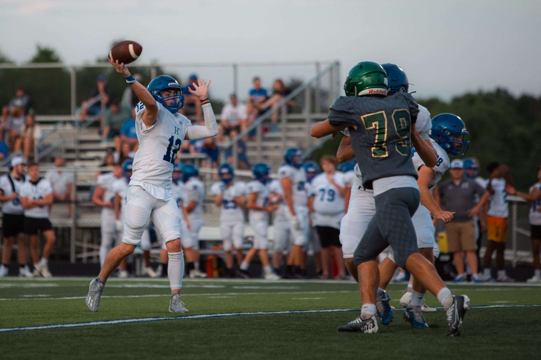 A high school quarterback preparing to throw a football during a game