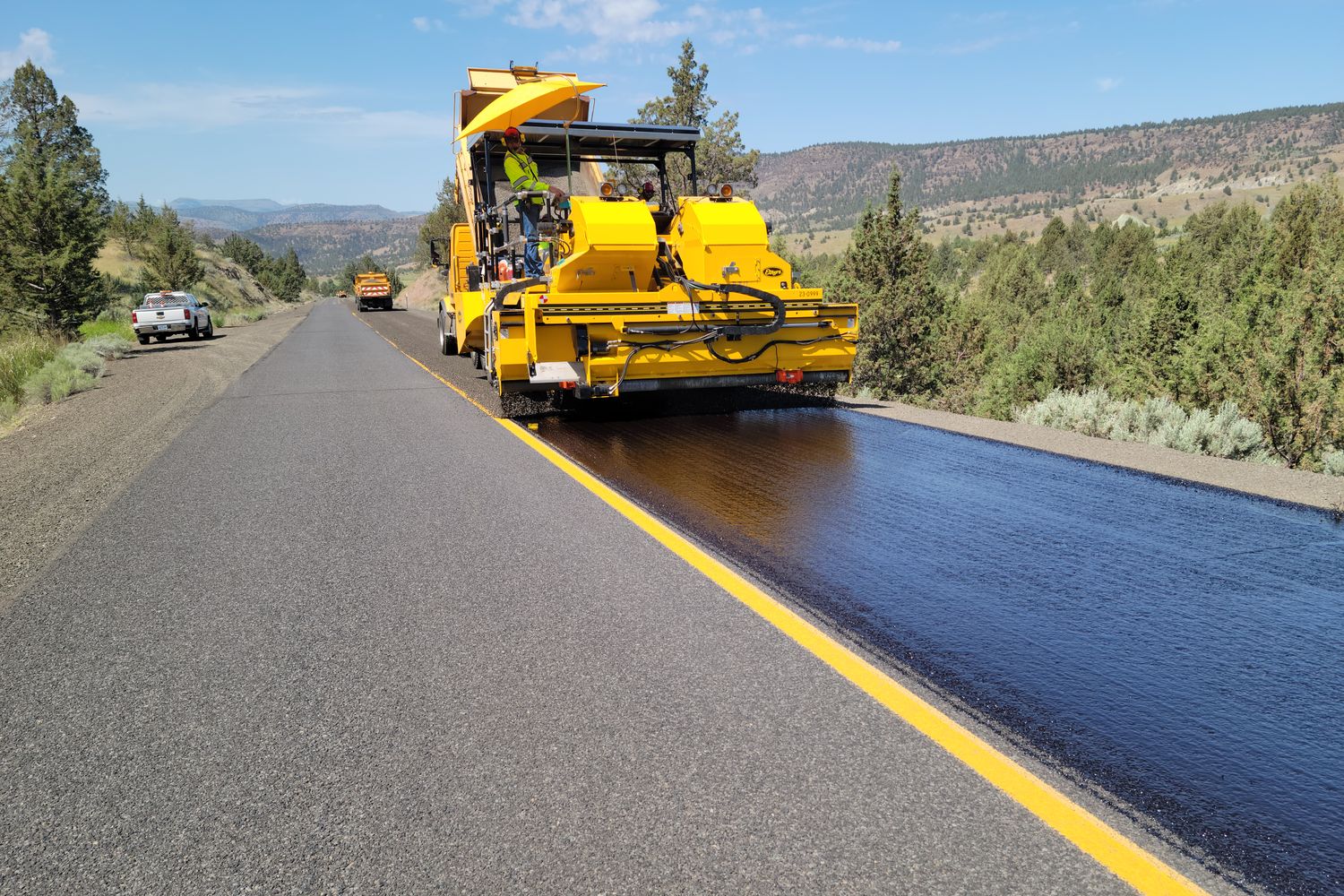 Heavy construction equipment parked at a rural county road department site