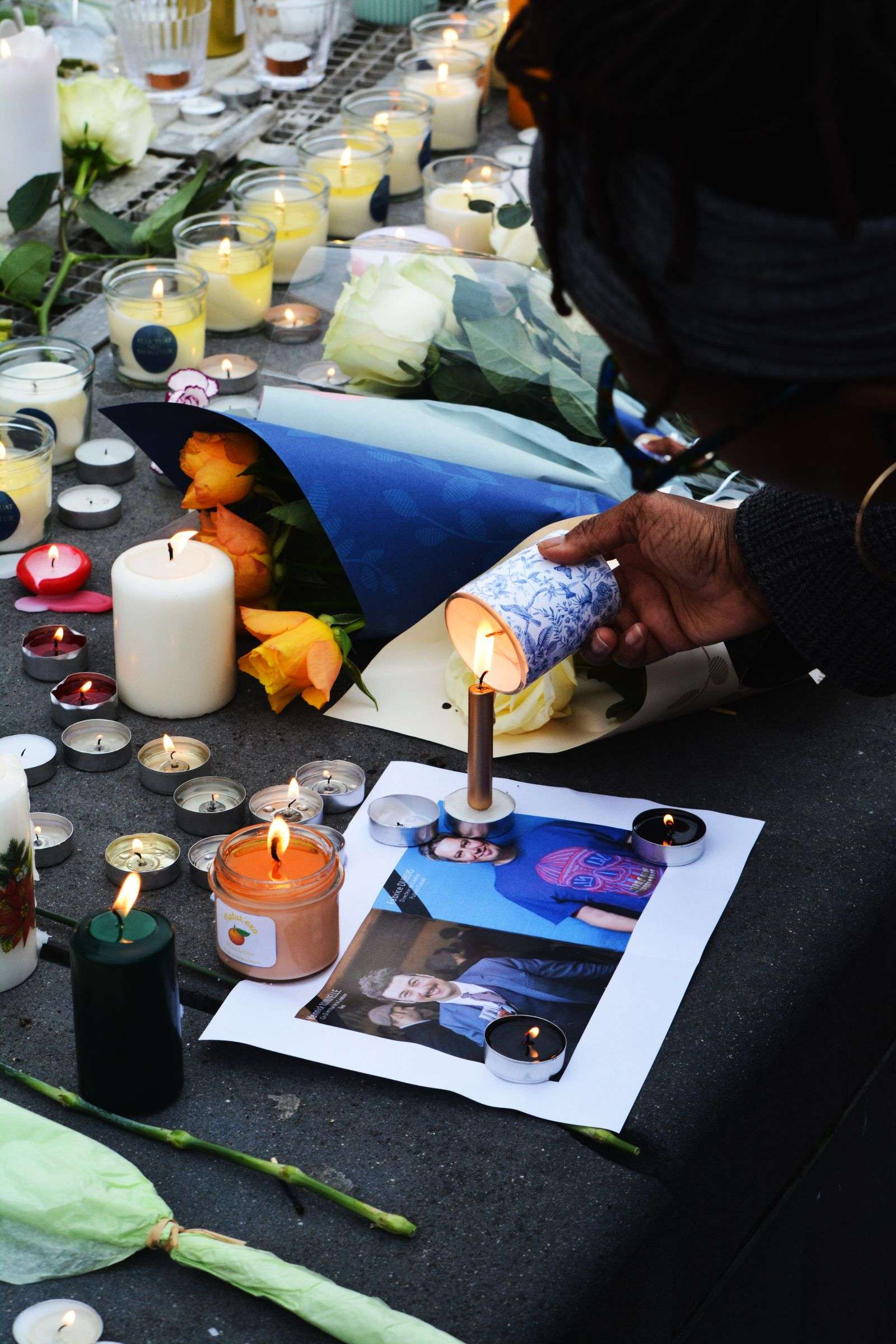 Candles and flowers arranged at a memorial vigil