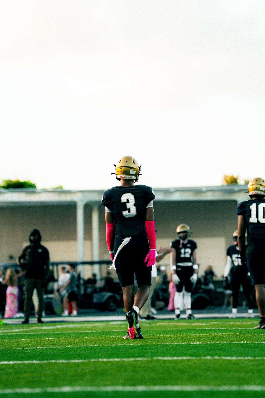High school football players in uniform competing on the field during a game