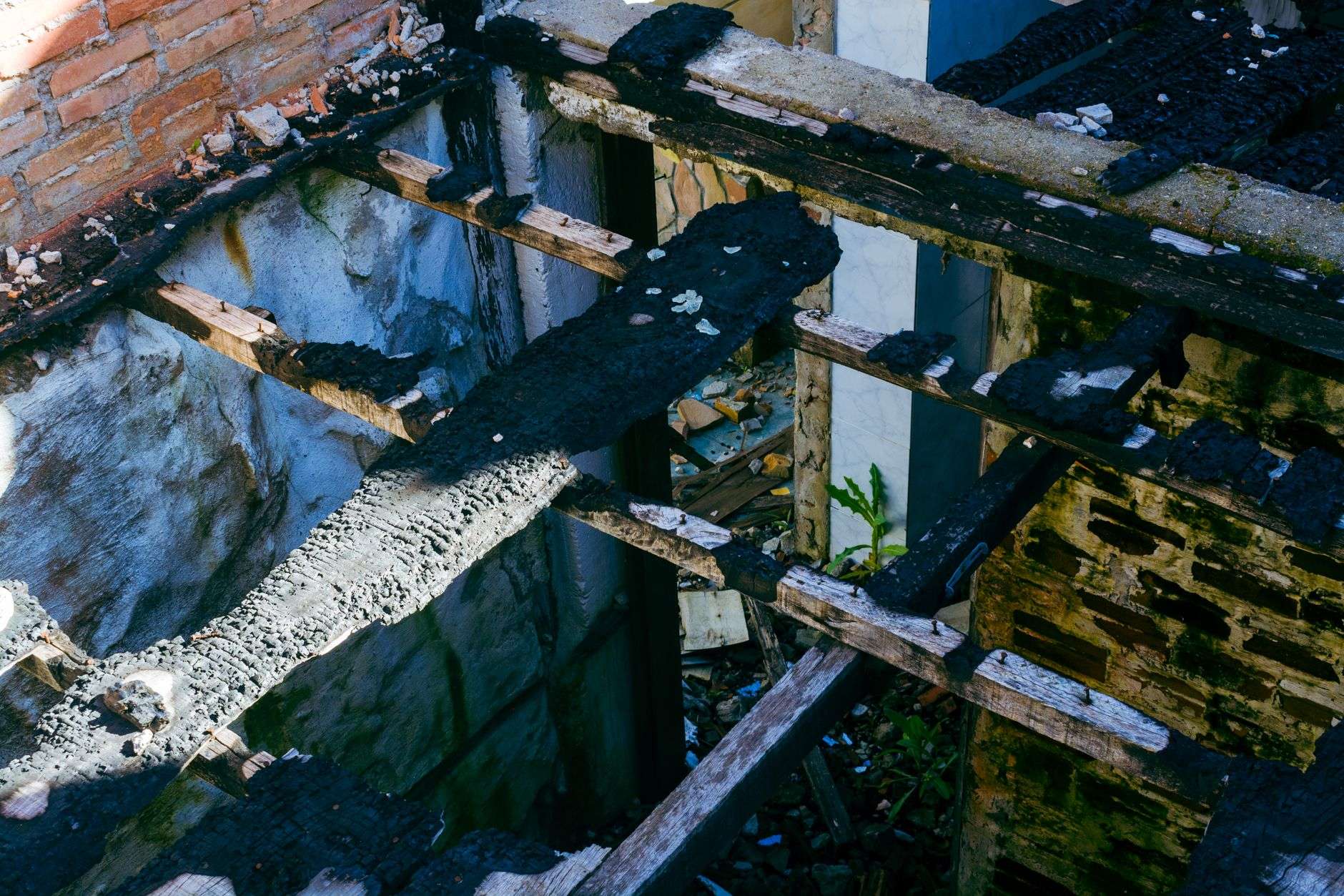 Charred remains of a small wooden structure after a fire