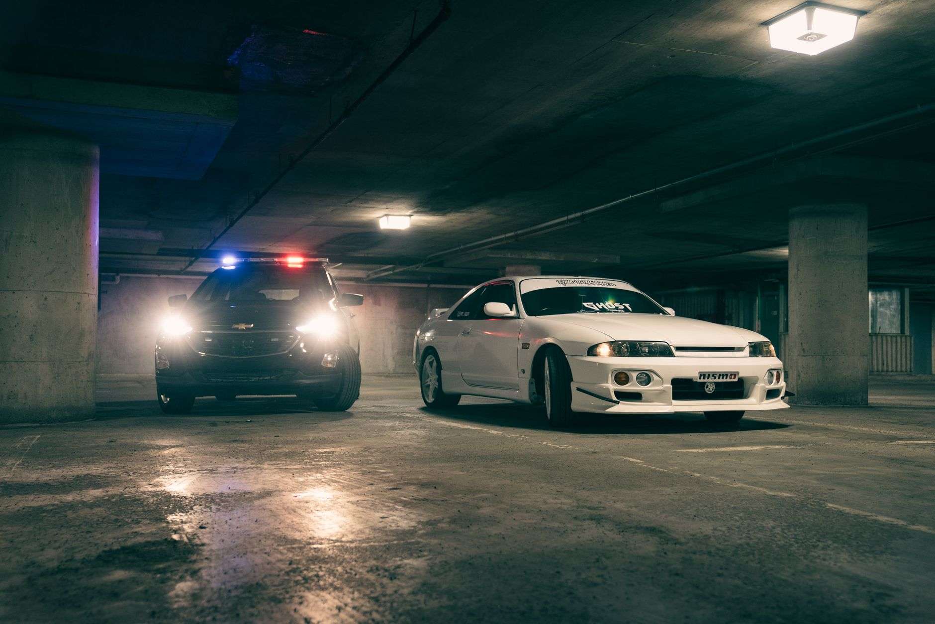 Police patrol car with emergency lights in a retail store parking lot