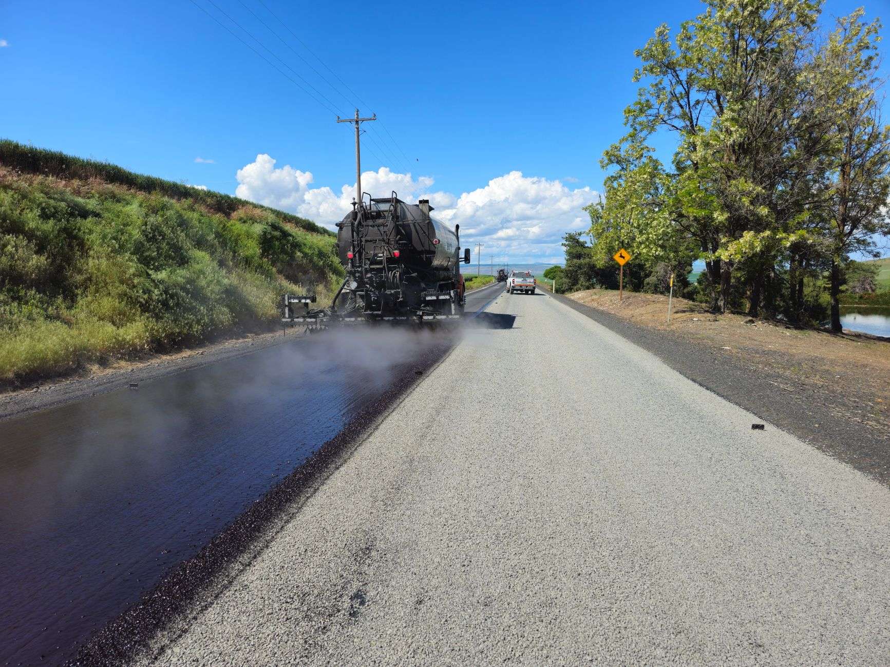 Construction crew resurfacing an asphalt roadway in a residential area