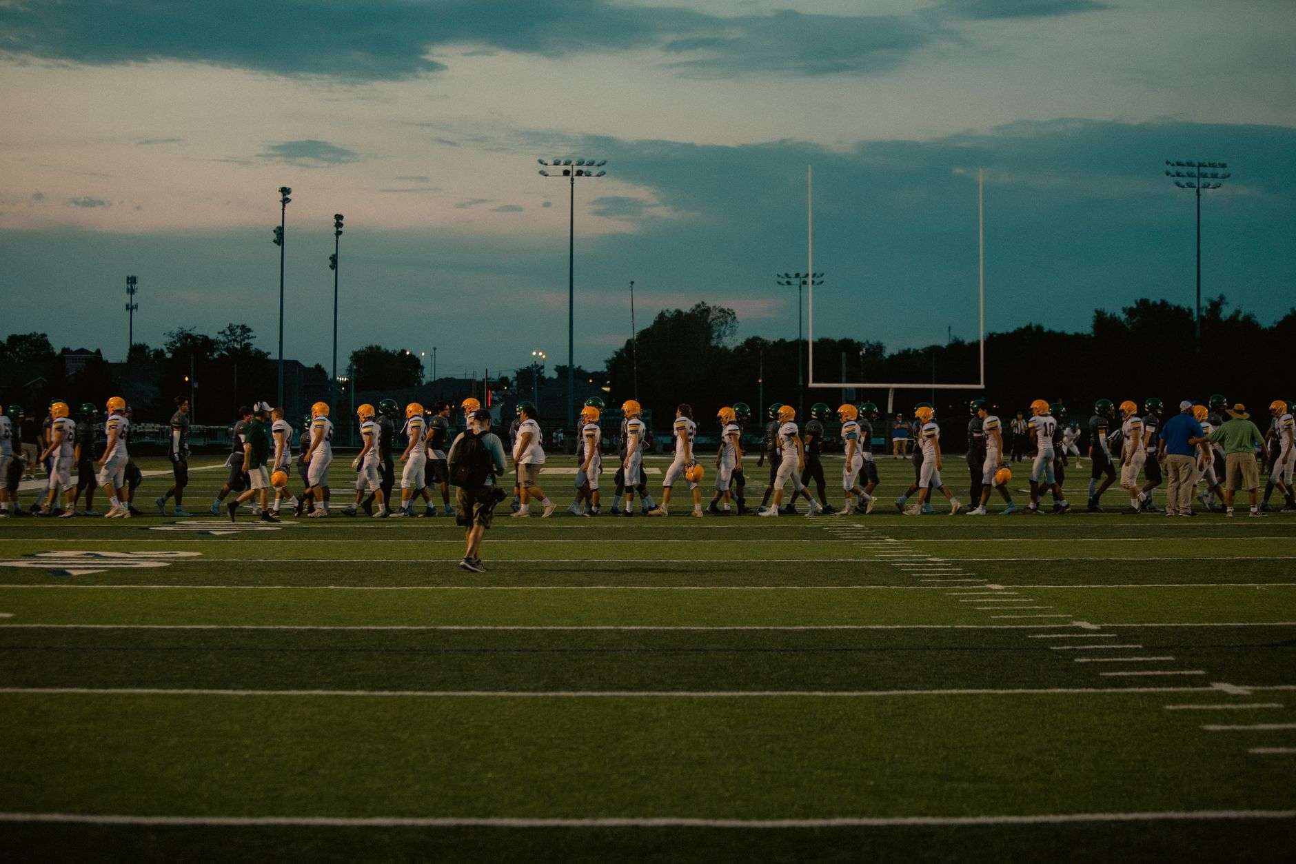 Empty high school football field and stadium lights before a game