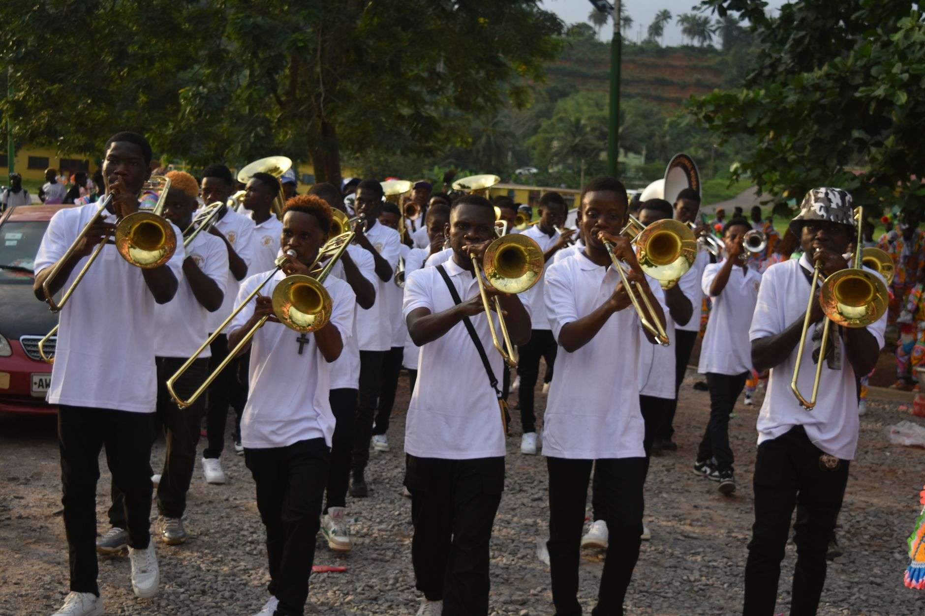 Marching band members playing brass instruments during a halftime performance