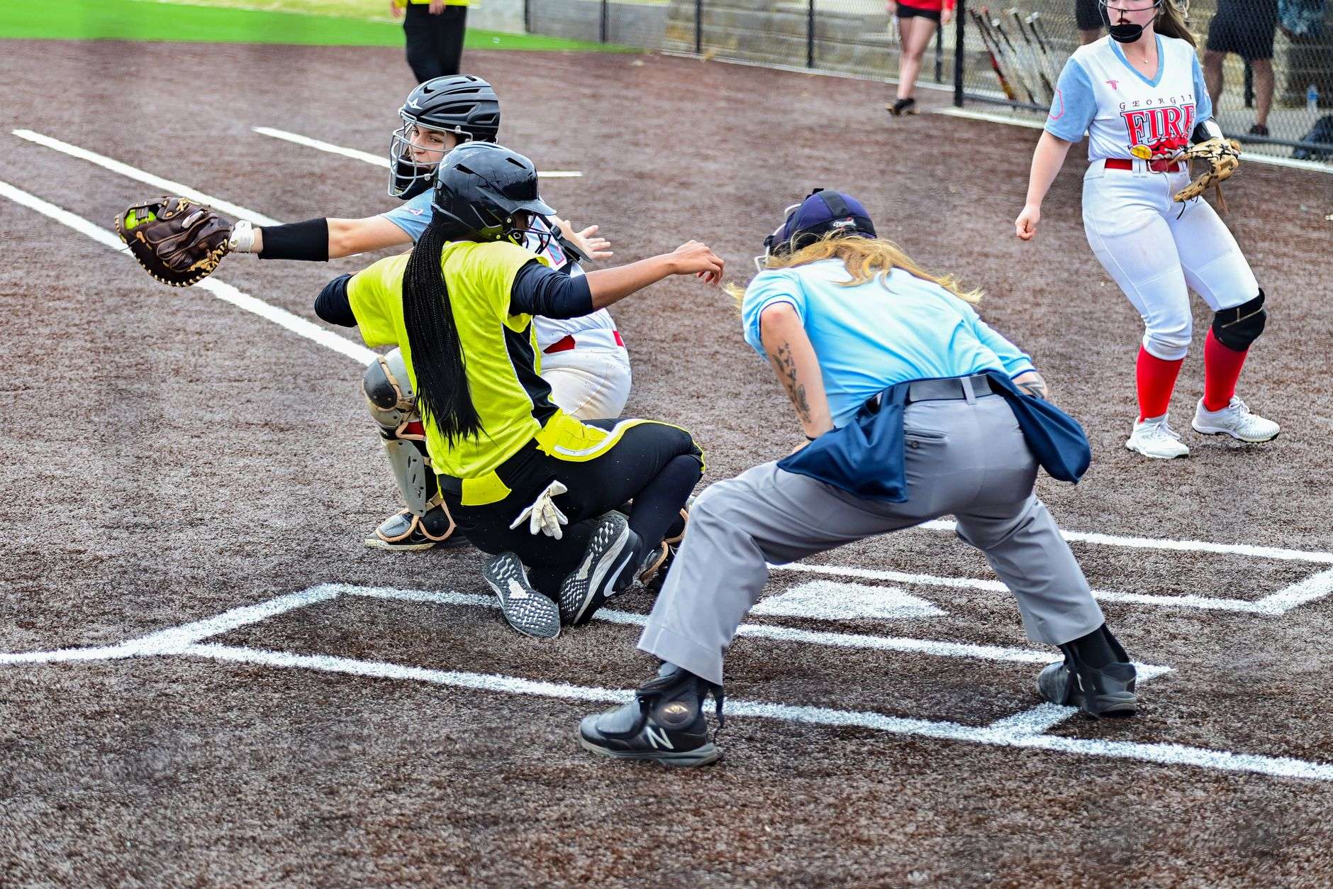 Players and fans gathered along the baseline of a softball field during a tournament