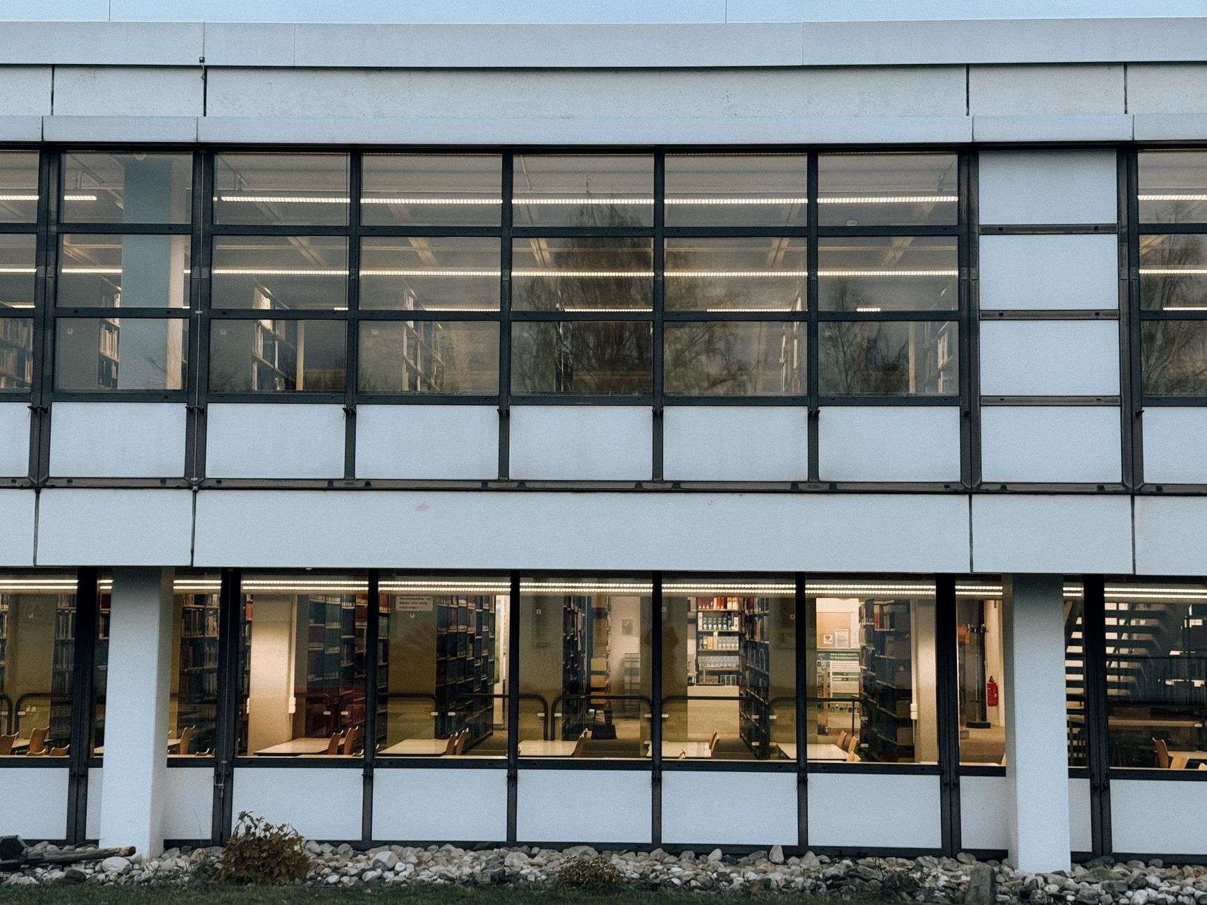 Exterior of a modern public library building with large windows and an entrance walkway