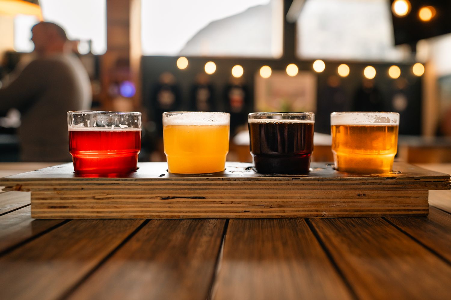 Glasses of craft beer lined up on the wooden bar of a taproom