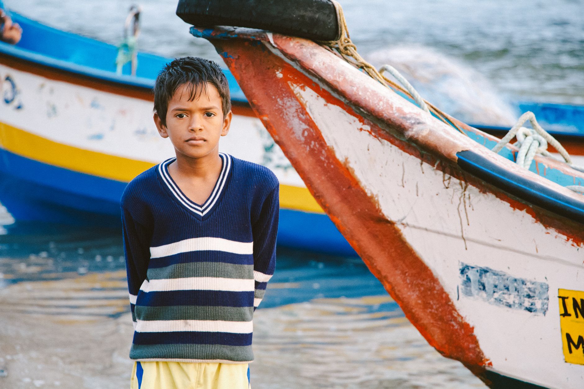 Children holding fishing rods aboard a boat on the water