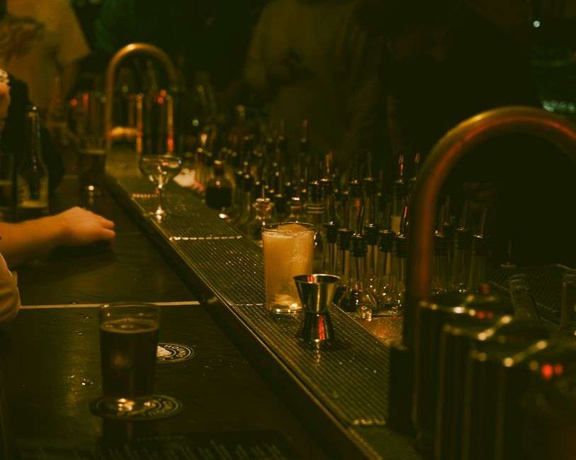 Dim lighting over an elegant craft cocktail bar interior