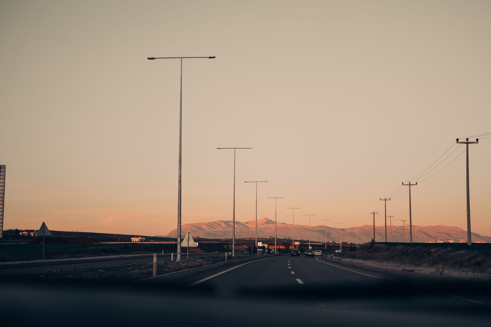 Camera mounted on a pole beside a highway with traffic passing