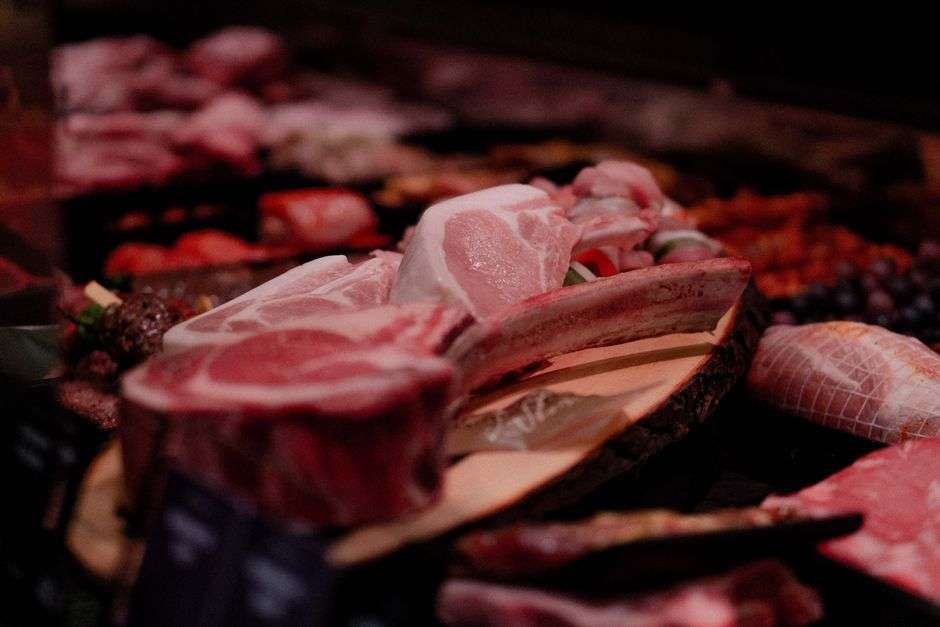 A butcher shop display case with fresh hand-cut meats