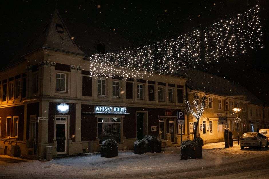 Holiday lights strung across a small-town street at night