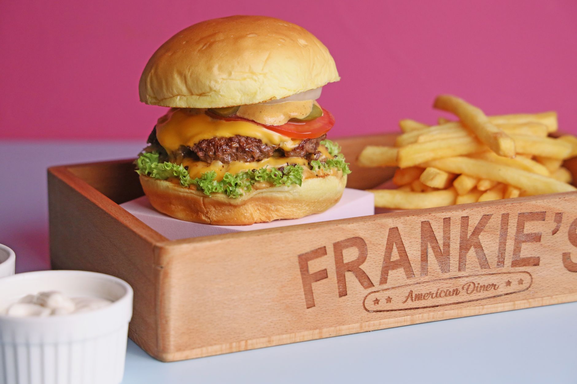 Cheeseburger with lettuce, tomato and onion served with fries at a diner