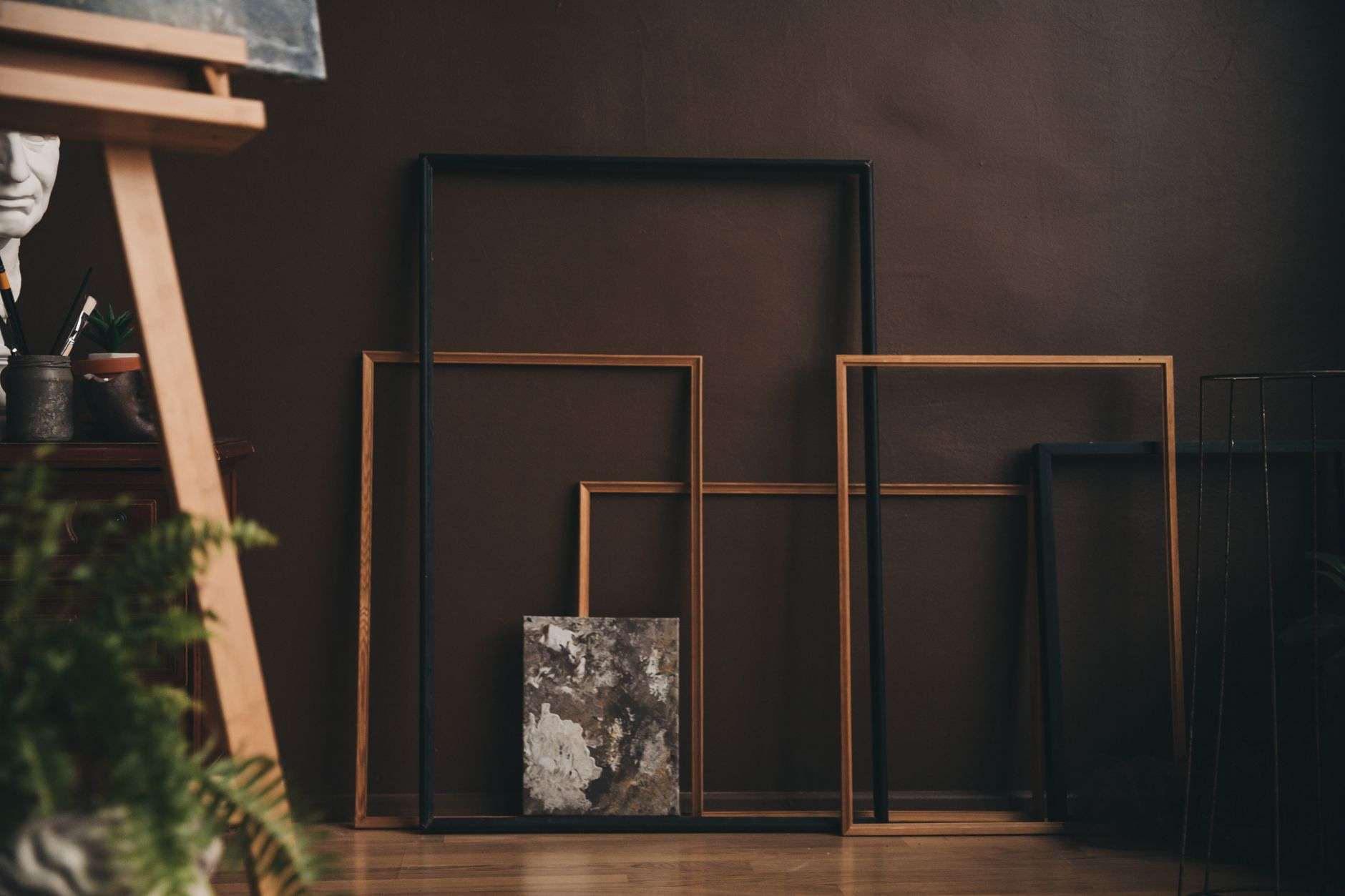 Assorted wooden picture frame samples displayed on a workshop wall